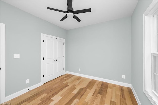 unfurnished bedroom with light wood finished floors, baseboards, and a ceiling fan