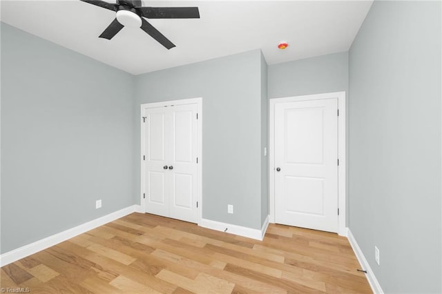 unfurnished bedroom with light wood-type flooring, baseboards, a closet, and ceiling fan