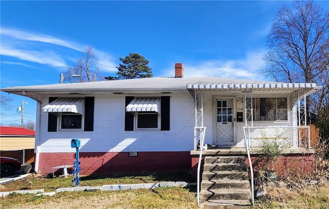 view of front facade with roof with shingles, a porch, crawl space, and a chimney