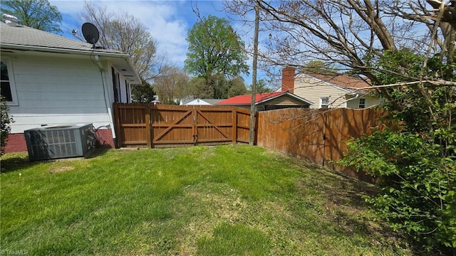 view of yard featuring fence, cooling unit, and a gate