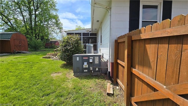view of yard featuring fence, an outbuilding, and a storage unit