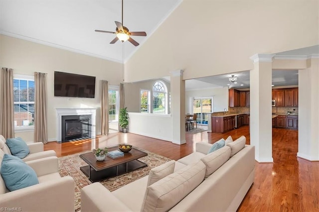 living room featuring light hardwood / wood-style floors, high vaulted ceiling, a wealth of natural light, and ceiling fan