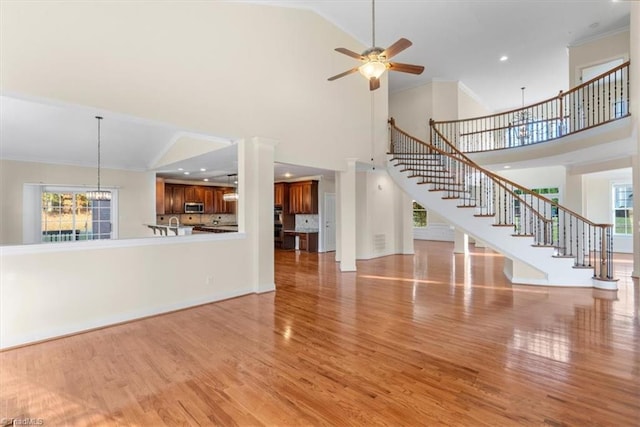 unfurnished living room featuring a wealth of natural light, light hardwood / wood-style flooring, and high vaulted ceiling