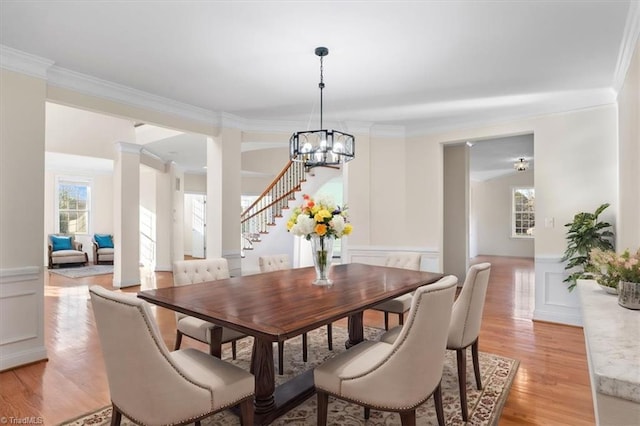 dining area with crown molding, light hardwood / wood-style flooring, and an inviting chandelier