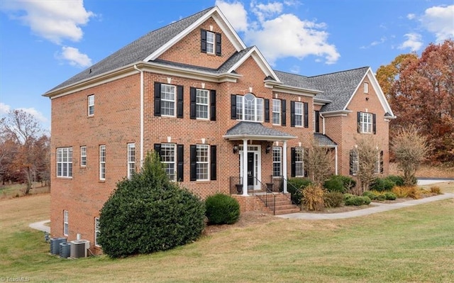 view of front of property with cooling unit and a front lawn