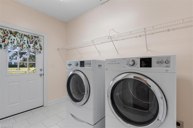 laundry room featuring light tile patterned floors and separate washer and dryer