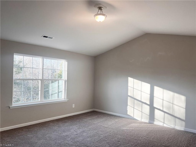 carpeted empty room with lofted ceiling