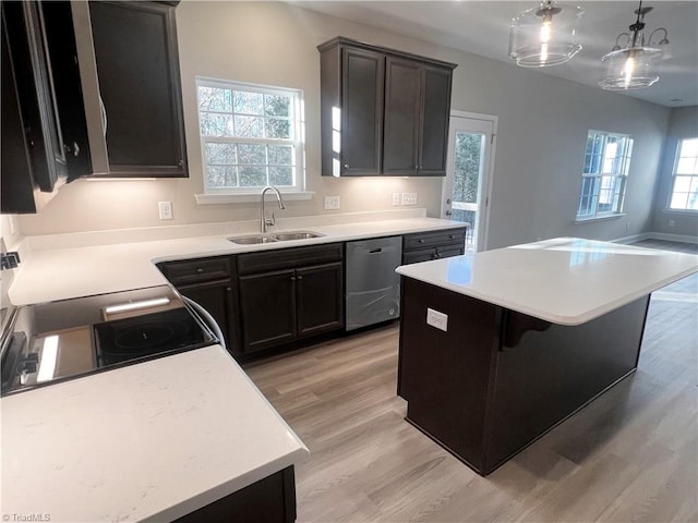 kitchen with light wood-style flooring, a sink, stainless steel dishwasher, a center island, and light countertops