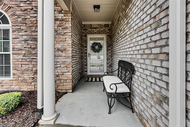 view of exterior entry featuring stone siding and brick siding