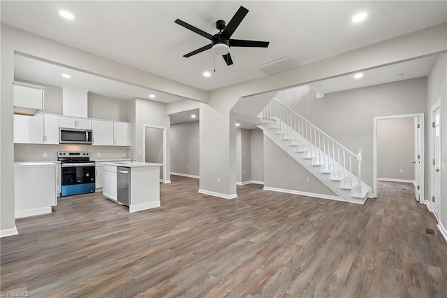2500 Lomond St, Winston-Salem, NC 27127 - kitchen with stainless steel appliances, open floor plan, wood finished floors, light countertops, and white cabinets