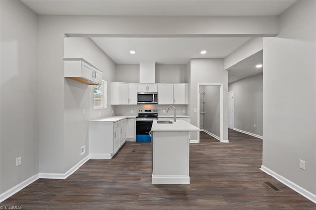 2500 Lomond St, Winston-Salem, NC 27127 - kitchen featuring appliances with stainless steel finishes, a center island with sink, dark wood-style flooring, white cabinetry, and light countertops