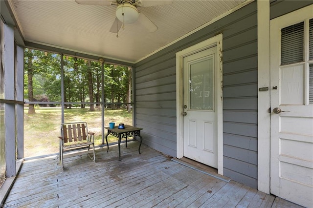 unfurnished sunroom with ceiling fan