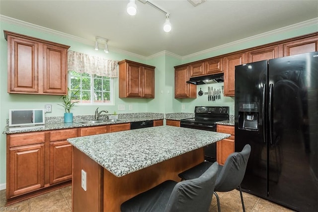 304 Walnut Crossing Dr, Whitsett, NC 27377 - kitchen with black appliances, a sink, a kitchen bar, under cabinet range hood, and light stone counters