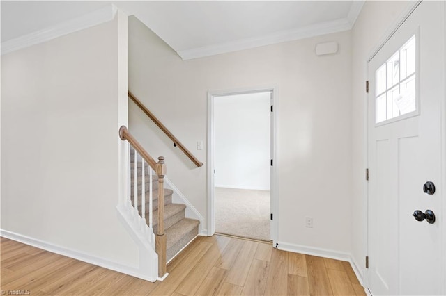 entryway featuring stairs, crown molding, light wood-style flooring, and baseboards