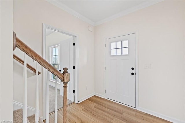 foyer featuring stairway, light wood-style flooring, crown molding, and baseboards