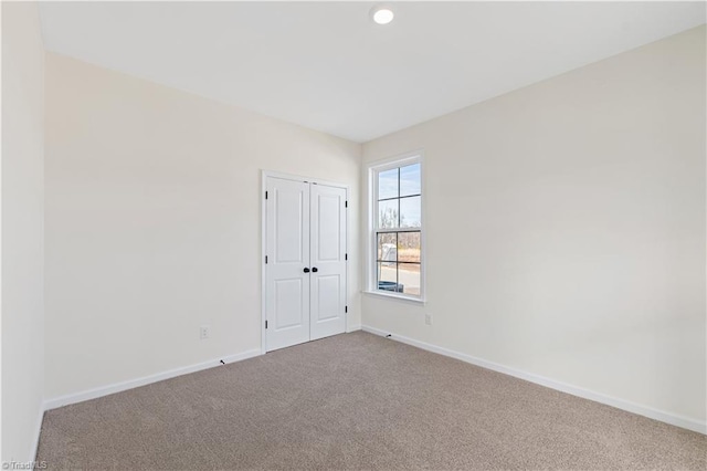 carpeted spare room featuring recessed lighting and baseboards