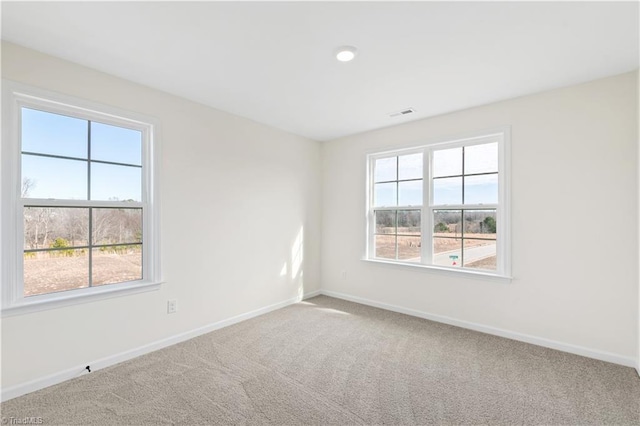 spare room with visible vents, baseboards, and carpet flooring