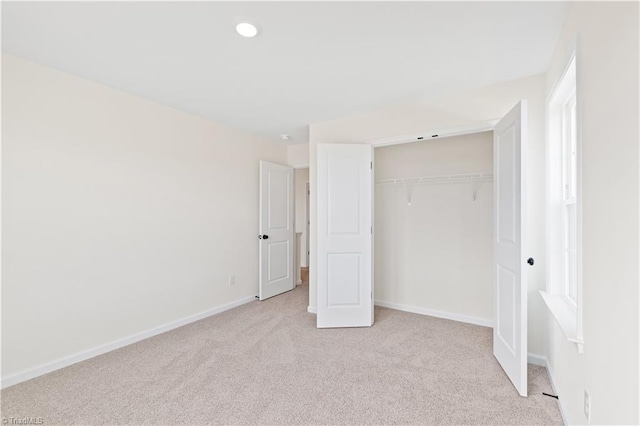 unfurnished bedroom with recessed lighting, a closet, baseboards, and light colored carpet