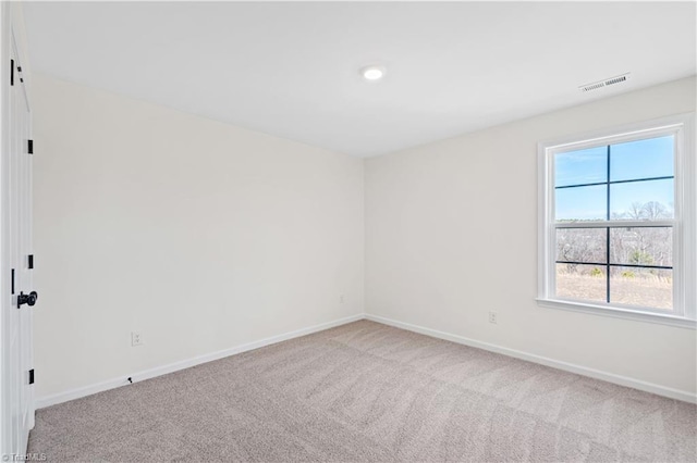 carpeted empty room featuring visible vents and baseboards