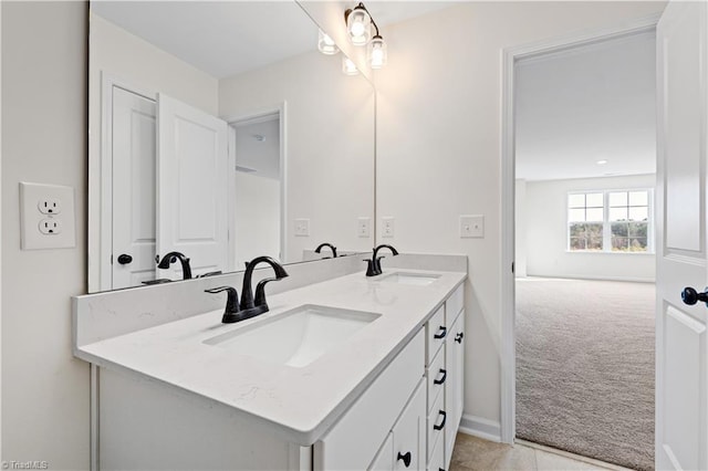 full bath featuring double vanity, baseboards, and a sink