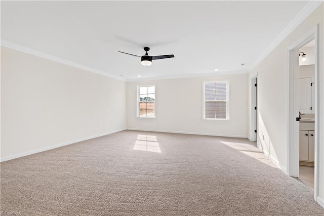 spare room featuring light carpet, crown molding, and a ceiling fan