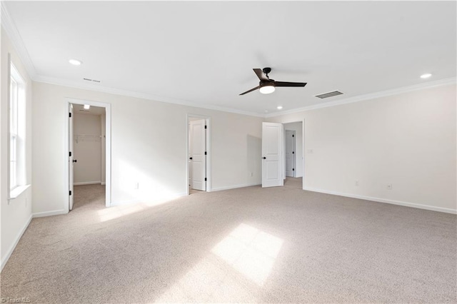 interior space featuring visible vents, crown molding, baseboards, light colored carpet, and ceiling fan