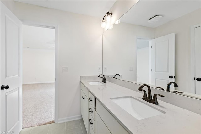 full bath featuring double vanity, baseboards, tile patterned floors, and a sink