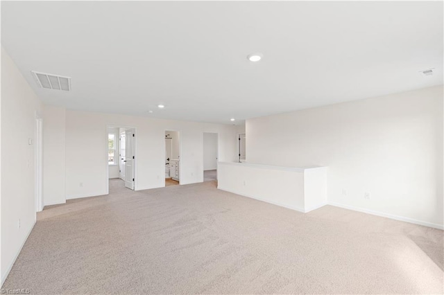 spare room with recessed lighting, visible vents, light colored carpet, and baseboards