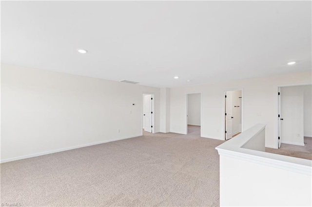 unfurnished room with light carpet, recessed lighting, and baseboards