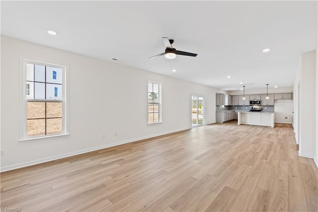 unfurnished living room featuring baseboards, recessed lighting, light wood-type flooring, and ceiling fan