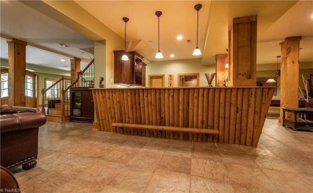 bar featuring pendant lighting and decorative columns