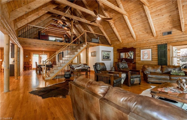 living room with ceiling fan, beamed ceiling, hardwood / wood-style floors, and high vaulted ceiling