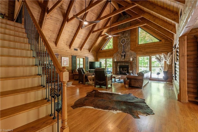 living room featuring ceiling fan, a fireplace, wood ceiling, and wood-type flooring