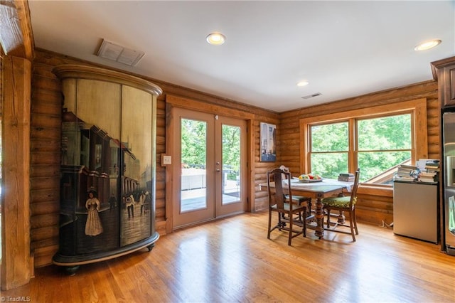 dining space featuring light wood-type flooring, log walls, and french doors