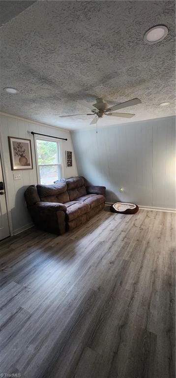 living area with wood finished floors, a textured ceiling, and ceiling fan