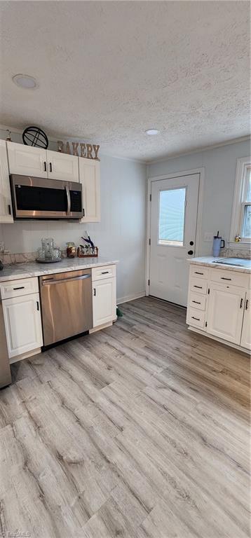 kitchen featuring white cabinets, light countertops, plenty of natural light, and stainless steel appliances