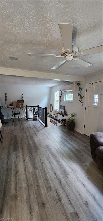 interior space with wood finished floors, a textured ceiling, and ceiling fan