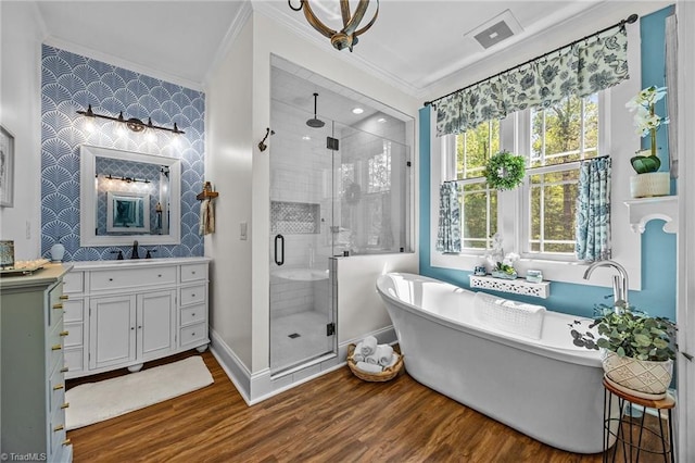 bathroom with vanity, wood finished floors, visible vents, ornamental molding, and a stall shower