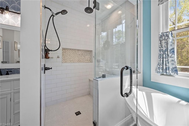 full bathroom featuring vanity, a freestanding bath, and a shower stall