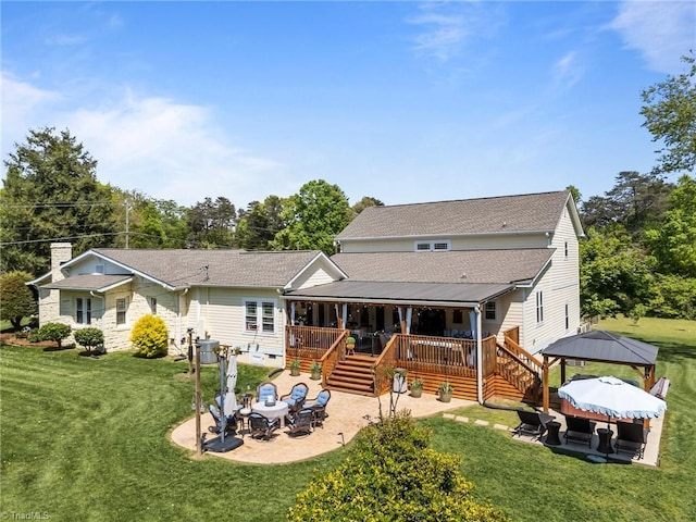 rear view of house with a lawn, a patio area, a deck, and a gazebo