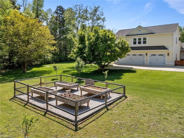 view of yard featuring an attached garage and a garden