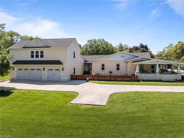 view of front of home with an attached garage, fence, a front yard, and concrete driveway