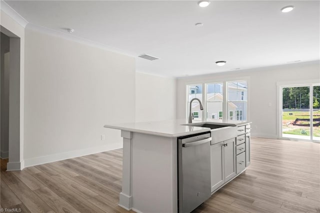 kitchen with light hardwood / wood-style flooring, an island with sink, and stainless steel dishwasher