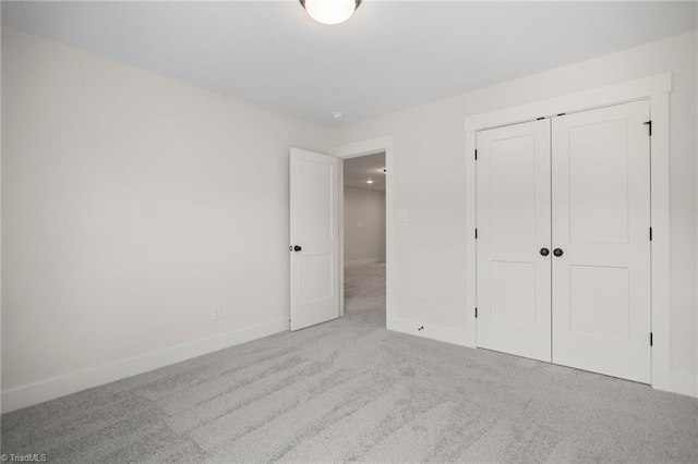 unfurnished bedroom with a closet and light colored carpet