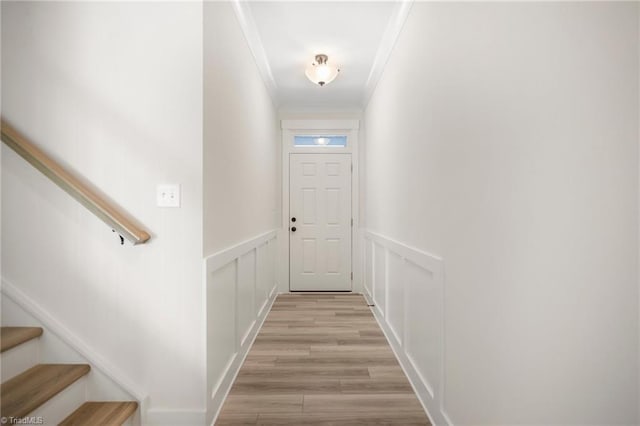 doorway featuring ornamental molding and light hardwood / wood-style floors