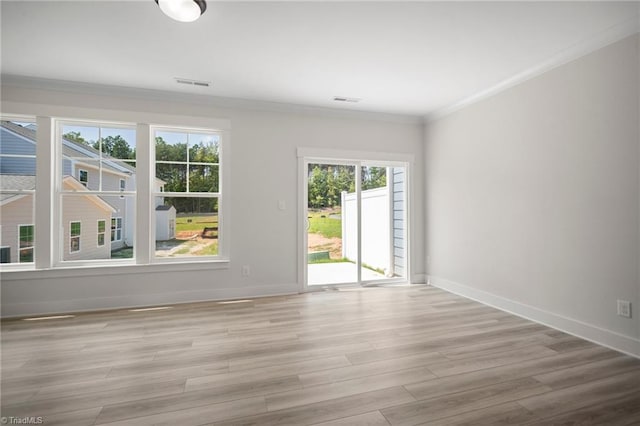 unfurnished room with light hardwood / wood-style floors and crown molding