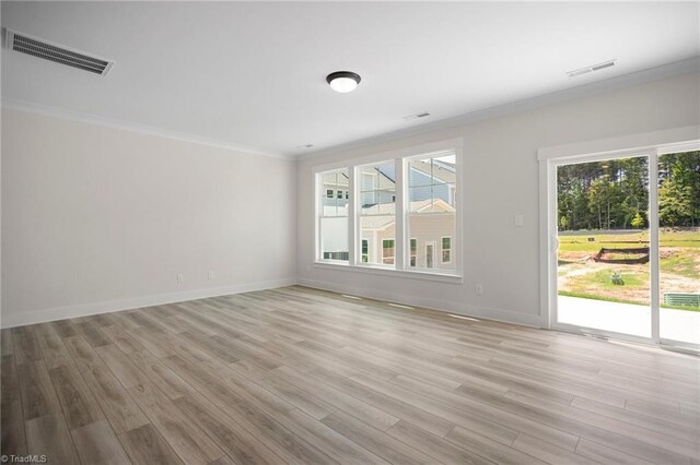 empty room with crown molding and hardwood / wood-style flooring