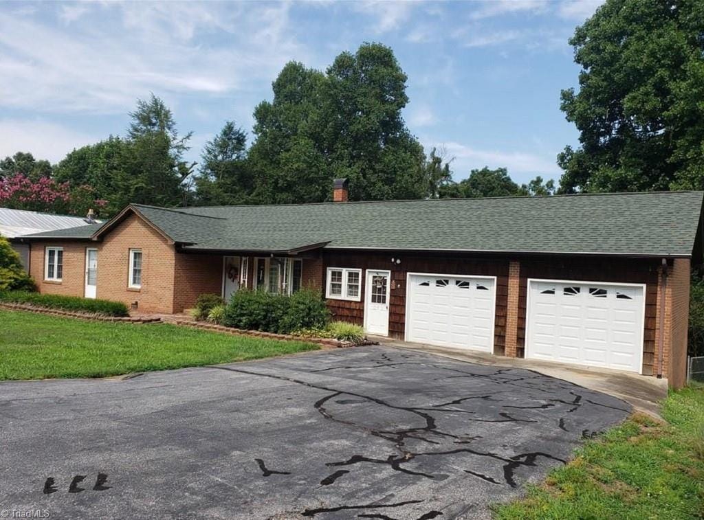 single story home featuring a garage and a front yard