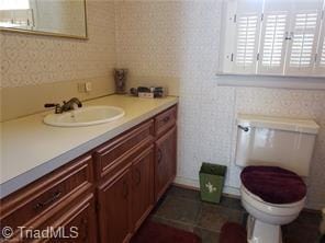 bathroom featuring vanity, toilet, and tile patterned flooring