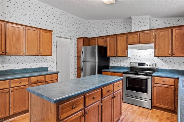 103 Forest Dr, King, NC 27021 - kitchen featuring appliances with stainless steel finishes, dark countertops, light wood-type flooring, under cabinet range hood, and a textured ceiling